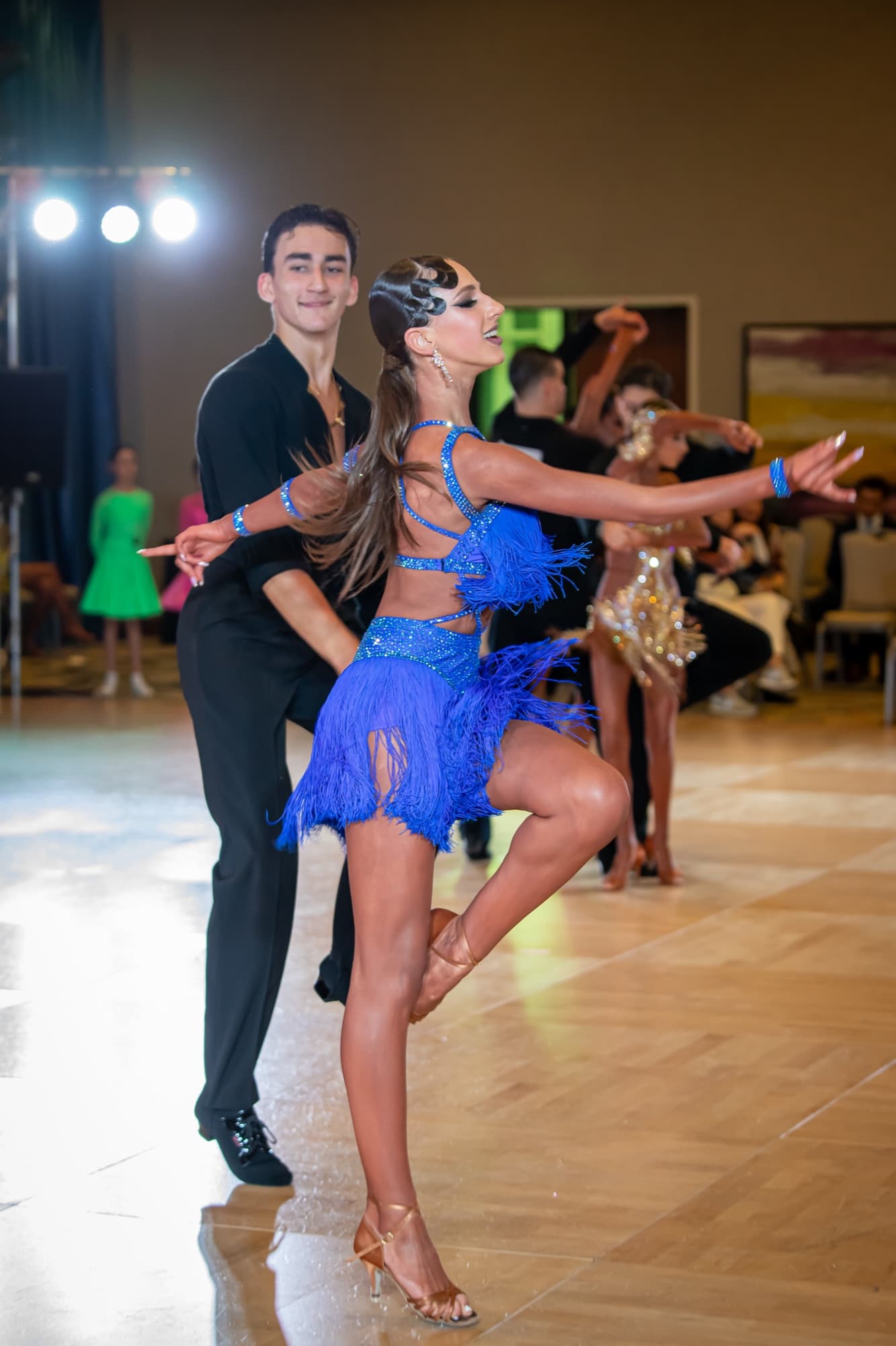 Latin dancer in a blue fringe dress mid-routine